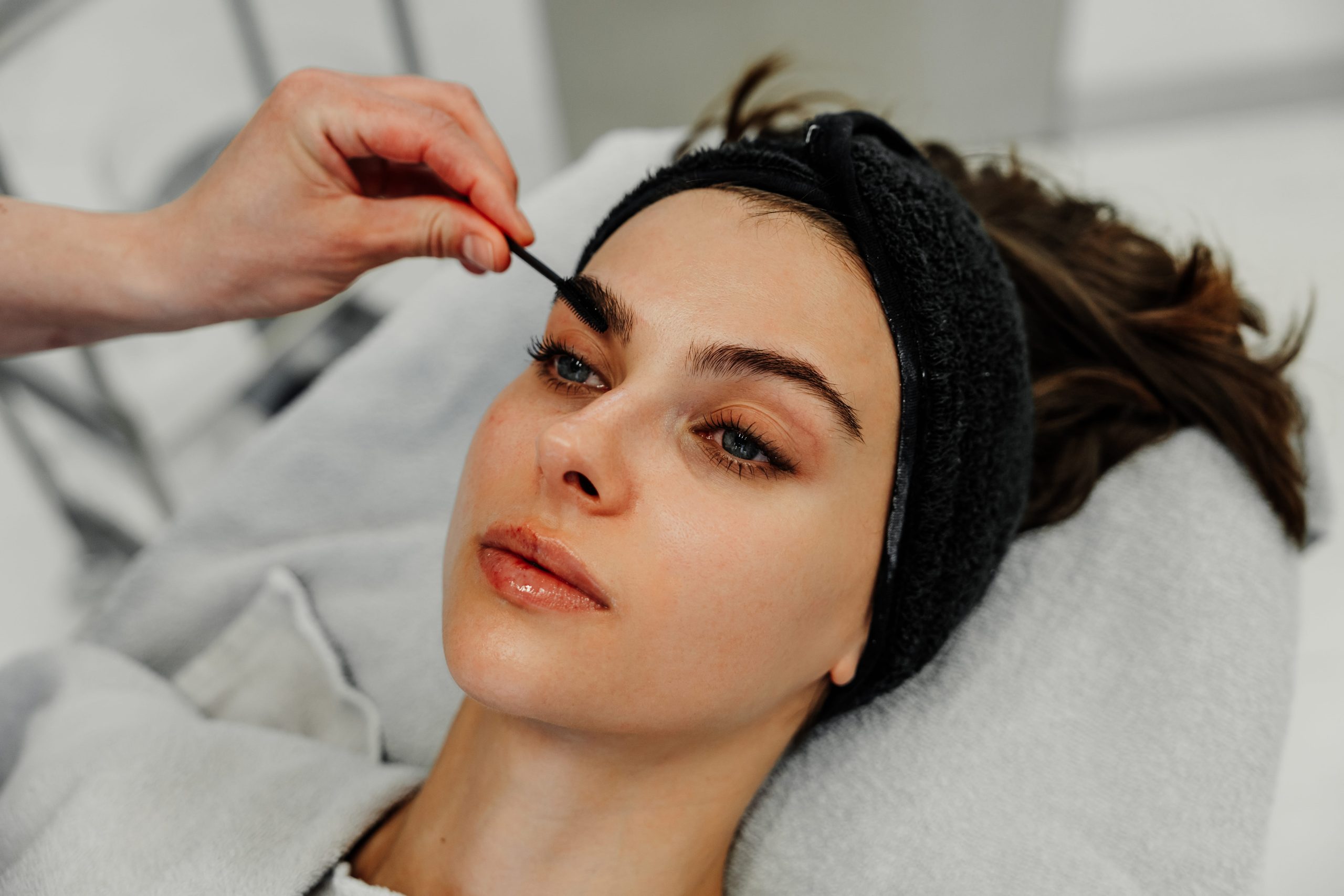 woman-getting-her-eyebrows-groomed-at-beauty-salon